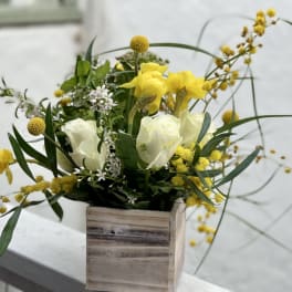 Yellow and white floral arrangement in a wooden box