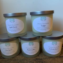 Five labeled soy candles in frosted glass jars with metal lids.