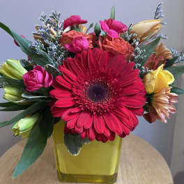 Bright mixed bouquet with a large red gerbera in a yellow vase