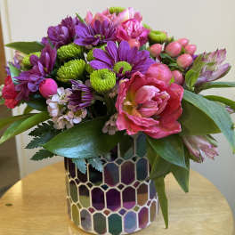 Pink and purple mixed bouquet in a mosaic glass vase
