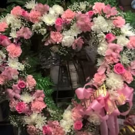 Pink and white floral wreaths with ribbon bows