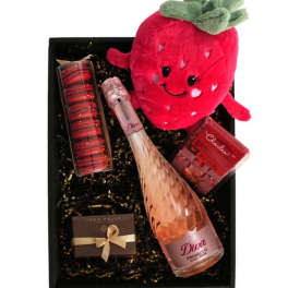 Gift box with strawberry plush, pink sparkling wine, macarons, and chocolates