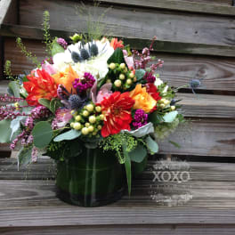 Colorful mixed flower arrangement in a dark vase