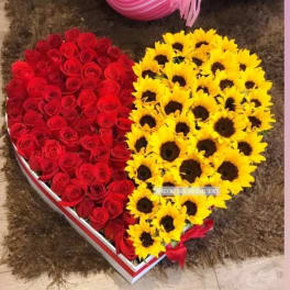 Heart-shaped box filled with red roses and yellow sunflowers