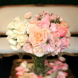 Bouquet of pale pink and cream roses in a clear glass vase