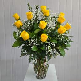 Yellow roses in a clear glass vase with white baby's breath