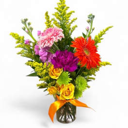 Colorful mixed bouquet in a glass vase with an orange ribbon