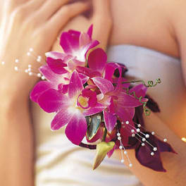 Pink orchid corsage with pearl accents on a wrist