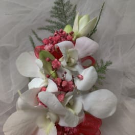 White orchid bouquet with pink accents and red ribbon