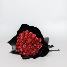 Bouquet of red roses wrapped in black paper