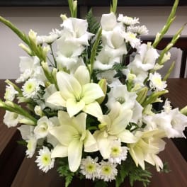 White lilies and daisies arranged in a low bouquet