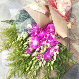 Bouquet of purple orchids with green filler wrapped in brown paper