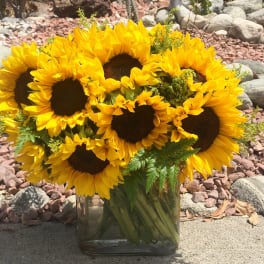 Bouquet of yellow sunflowers in a clear glass vase