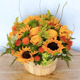 Basket of sunflowers and yellow roses with orange accents