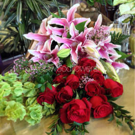 Bouquet of pink lilies and red roses with greenery