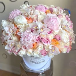 Large pastel bouquet of roses, orchids, and peonies in a white hat box