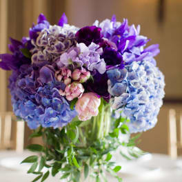 Purple and blue hydrangea bouquet in a clear glass vase