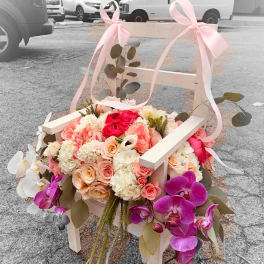 Flower-covered chair with pink ribbons and orchids