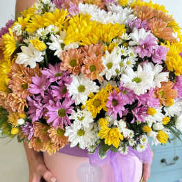 Large mixed daisy bouquet in a pink hat box with a purple ribbon