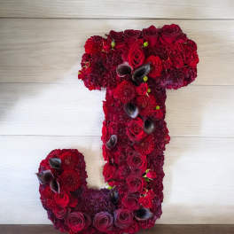 Floral arrangement shaped like the number 1 in deep red and burgundy blooms.