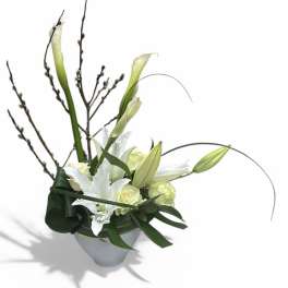 White calla lilies and roses in a white vase with tall branches