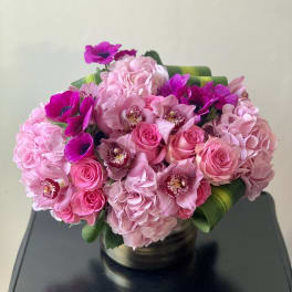 Pink bouquet of roses, hydrangeas, and orchids in a vase