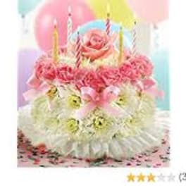 Pink floral birthday cake with candles and balloons