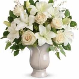 White lilies and cream roses in a pale vase