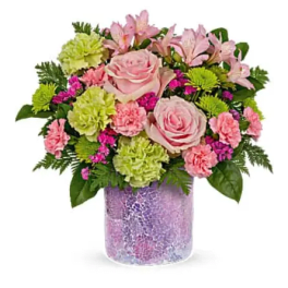 Pink roses and mixed blooms arranged in a purple vase