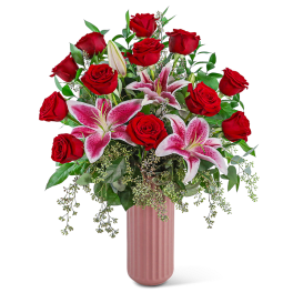 Red roses and pink lilies in a tall pink vase