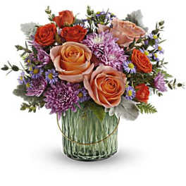 Bouquet of peach and orange roses with purple flowers in a glass vase
