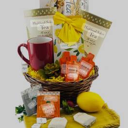 Gift basket with tea packets, honey bottles, a mug, and a lemon plush