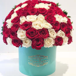 Red and white roses arranged in a turquoise hat box