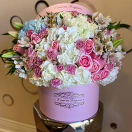 Pink and white bouquet in a round hatbox