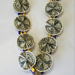 Ribbon lei with folded dollar bills and a coin pendant