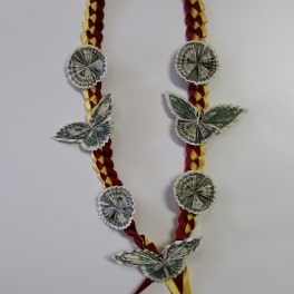 Braided ribbon garland decorated with folded dollar bills and butterfly shapes