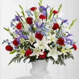 Red, white, and purple mixed flower arrangement in a white vase