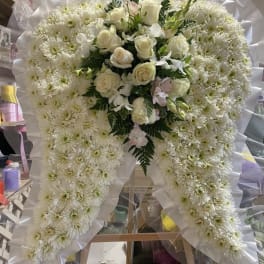 White floral standing spray with roses and chrysanthemums on an easel