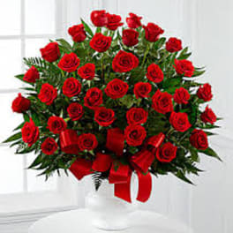 Bouquet of red roses with a red ribbon in a white vase