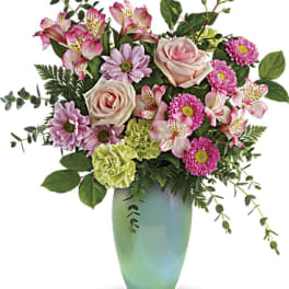 Mixed pink and lavender flowers in a green vase