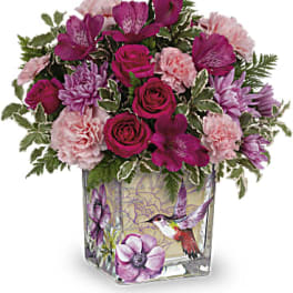 Pink and purple mixed bouquet in a square glass vase