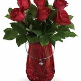 Bouquet of red roses in a red vase with a heart charm