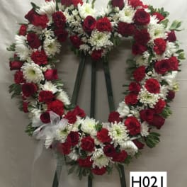 Heart-shaped red and white floral wreath on an easel