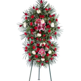 Standing funeral spray with red and white flowers on a tripod easel