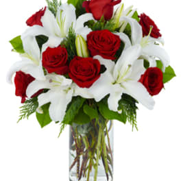 Red roses and white lilies in a clear glass vase