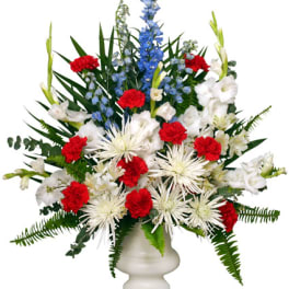 Red, white, and blue floral arrangement in a white vase