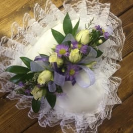 White lace ring pillow with purple and cream floral spray