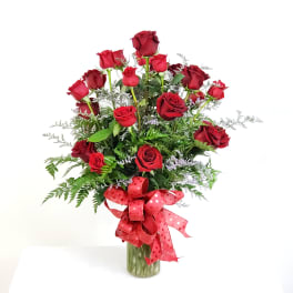 Red roses in a glass vase with a red ribbon bow