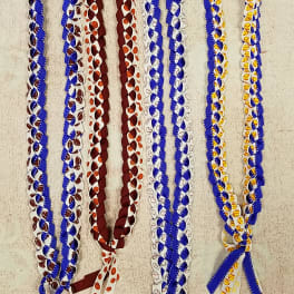 Braided ribbon leis in blue, maroon, white, and yellow with sports prints