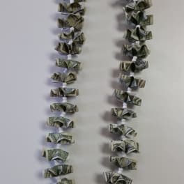 Money lei made from folded dollar bills and white beads